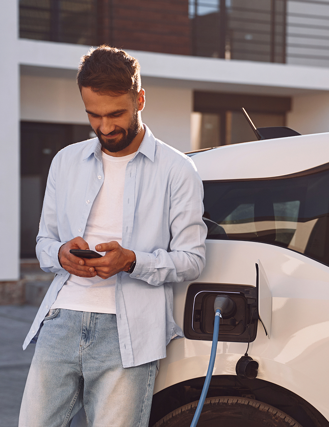 Man leaning on chargin EV car